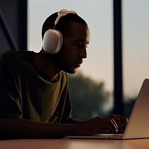 Man wearing headphones using a laptop