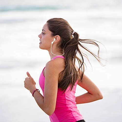 Woman jogging on the beach with earphones.