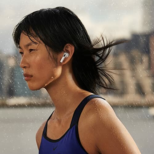 Woman running with earbuds in the rain